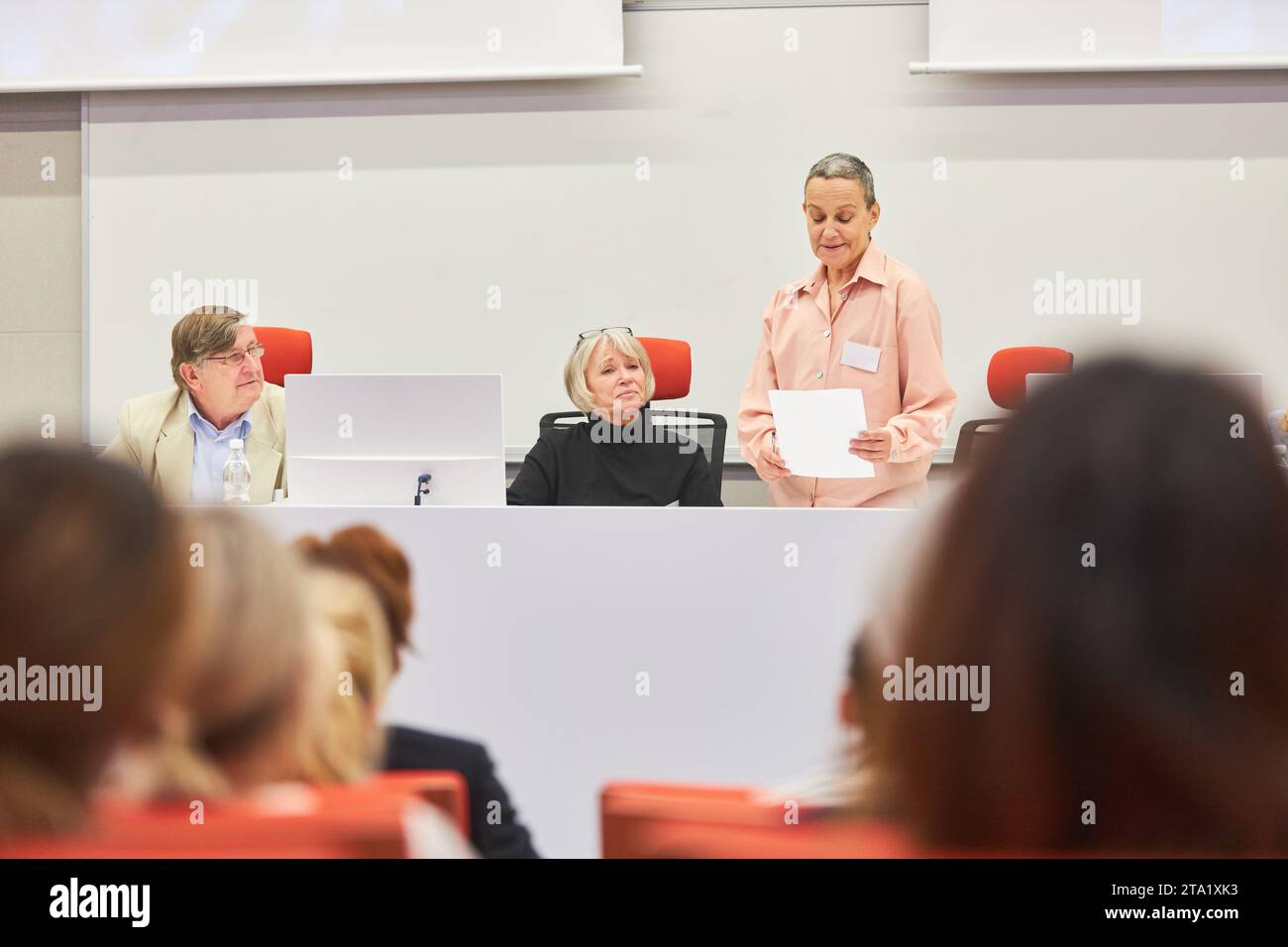 Male and female speakers at conference taking questions from people in