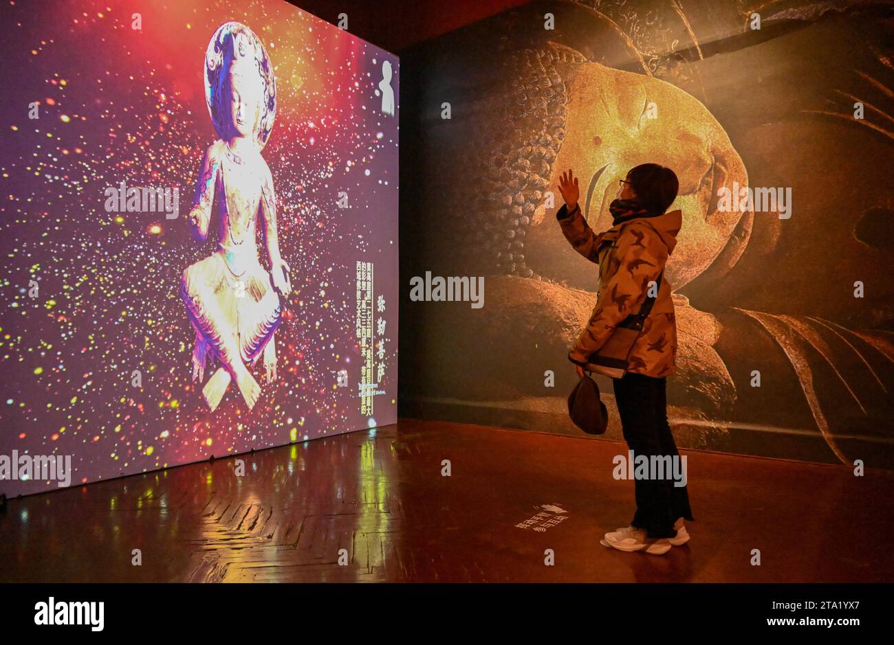 (231128) -- TIANJIN, Nov. 28, 2023 (Xinhua) -- A visitor views a digital exhibit at an exhibition themed on Dunhuang culture at the Tianjin Digital Art Museum in Tianjin, north China, Nov. 28, 2023. The exhibition will last until March 2024. (Xinhua/Sun Fanyue) Stock Photo