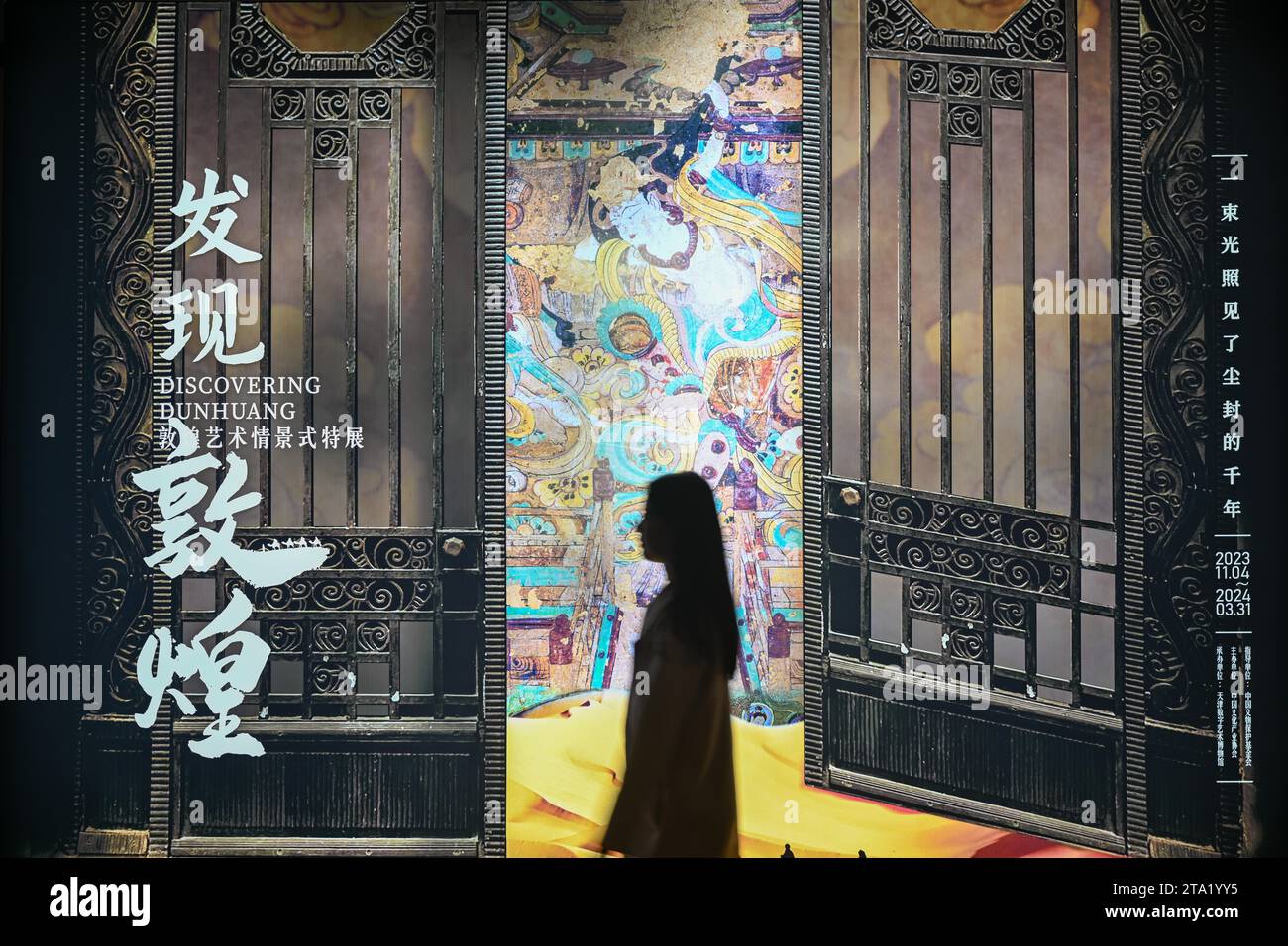 (231128) -- TIANJIN, Nov. 28, 2023 (Xinhua) -- A visitor views exhibits at an exhibition themed on Dunhuang culture at the Tianjin Digital Art Museum in Tianjin, north China, Nov. 28, 2023. The exhibition will last until March 2024. (Xinhua/Sun Fanyue) Stock Photo