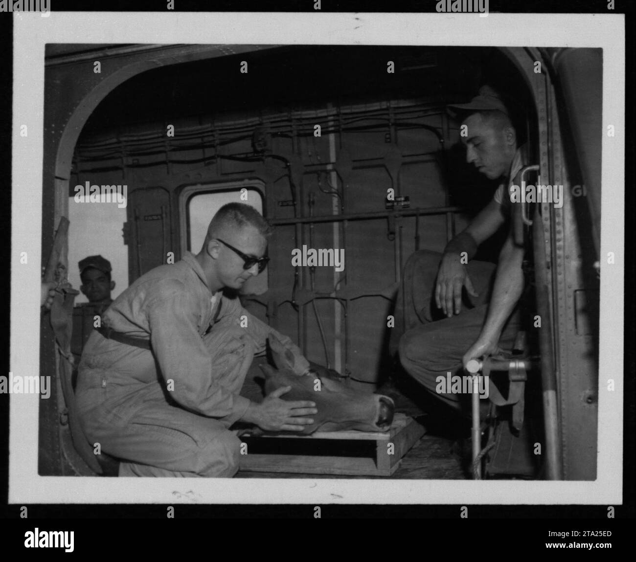 American soldier distributing supplies to Vietnamese civilians during the Vietnam War. The soldier interacts with locals as part of the People to People program, promoting goodwill and assistance between the two groups. The date of the image is July 24, 1962. Stock Photo