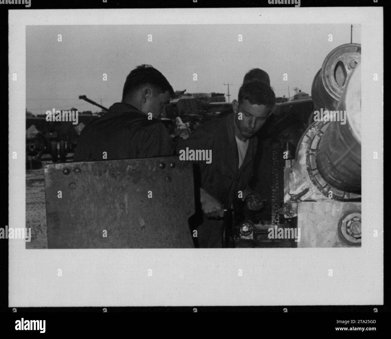 Maintenance crew members working on a damaged military vehicle during the Vietnam War. The image showcases the essential role of maintenance in keeping equipment and vehicles operational in demanding war environments. Stock Photo