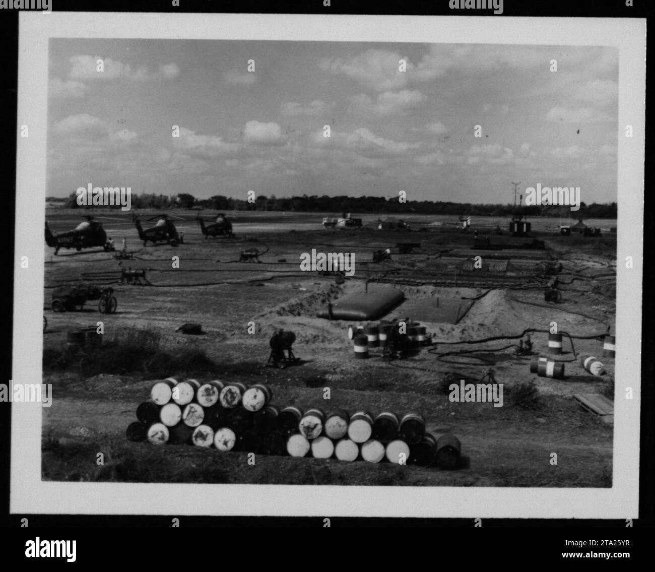 Caption: A fleet of helicopters undergoing maintenance at an American military base during the Vietnam War on July 24, 1962. These helicopters played a crucial role in providing transportation, logistics, and support for troops and operations in the region. Regular maintenance was crucial in ensuring the helicopters' operational readiness and maximizing their efficiency in the field. Stock Photo