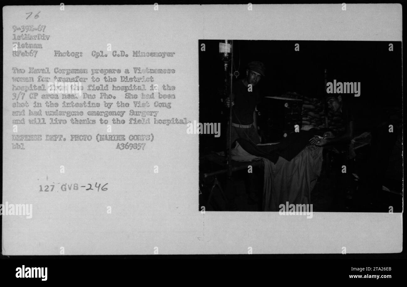 Caption: Two Haval Corpaman attending to a Vietnamese woman in the 3/7 CP area near Due Pho during MEDCAP 1967, on February 8, 1967. The woman, who had been shot in the intestine by the Viet Cong, was being prepared for transfer to the District hospital from the field hospital. Thanks to the emergency surgery performed at the field hospital, she would survive. Photograph taken by Cpl. C.D. Mincemayer. (DEFENSE DEPT. PRECTO (NARTHE CORP's) bbl A369857 127 GVB-246) Stock Photo