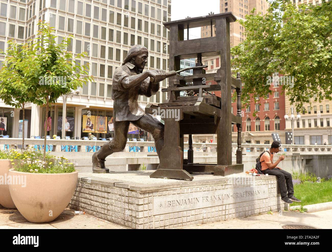 Philadelphia, PA, USA - May 29, 2018:  Man seat near the Benjamin Franklin Craftsman Sculpture near City Hall in Philadelphia PA. Stock Photo