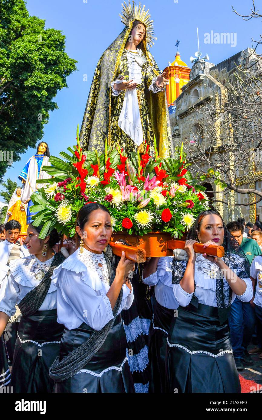 Mexican women devotees carry the religious palanquin during during the Good Friday procession, on the Holy week, Oaxaca de Juárez , Mexico Stock Photo
