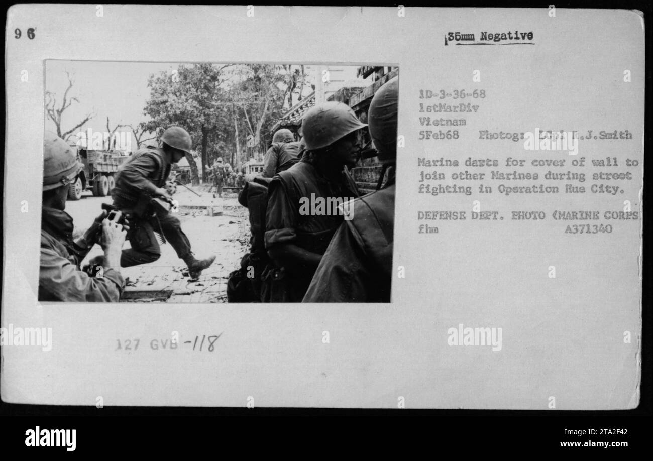 Marine darts for cover of wall to join fellow Marines during street fighting in Operation Hue City. Combat operations took place on February 5th, 1968. The photograph was taken by LCpl R.J. Smith, belonging to the 1st Marine Division in Vietnam. This image portrays the intensity of the battle. Stock Photo