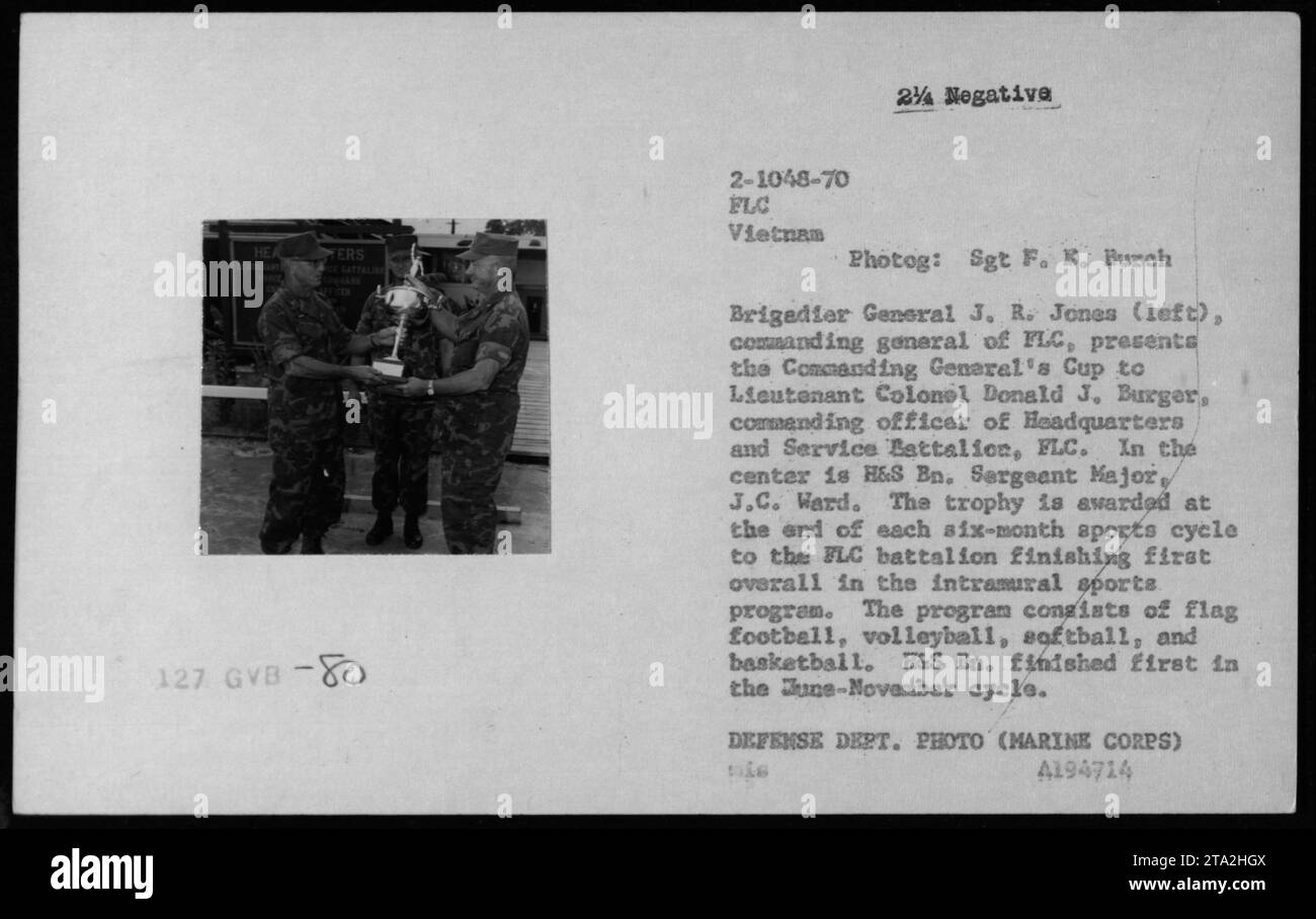 Brigadier General J.R. Jones presenting the Commanding General's Cup to Lieutenant Colonel Donald J. Burger during a ceremony in Vietnam. The cup is awarded to the Battalion that performs the best in the intramural sports program, which includes flag football, volleyball, softball, and basketball. H&S En. finished first in the June-November cycle. Stock Photo