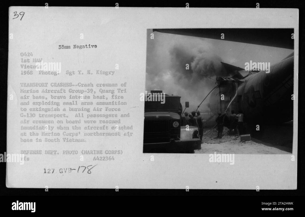 Marine crash crew members from Marine Aircraft Group-39 at Quang Tri air base extinguish a burning Air Force C-130 transport in South Vietnam in 1968. Despite intense heat, fire, and exploding ammunition, all passengers and air crew members were immediately rescued from the damaged aircraft. This photograph was taken by Sgt T. E. Kingry, under Defense Department grant A422364. Stock Photo