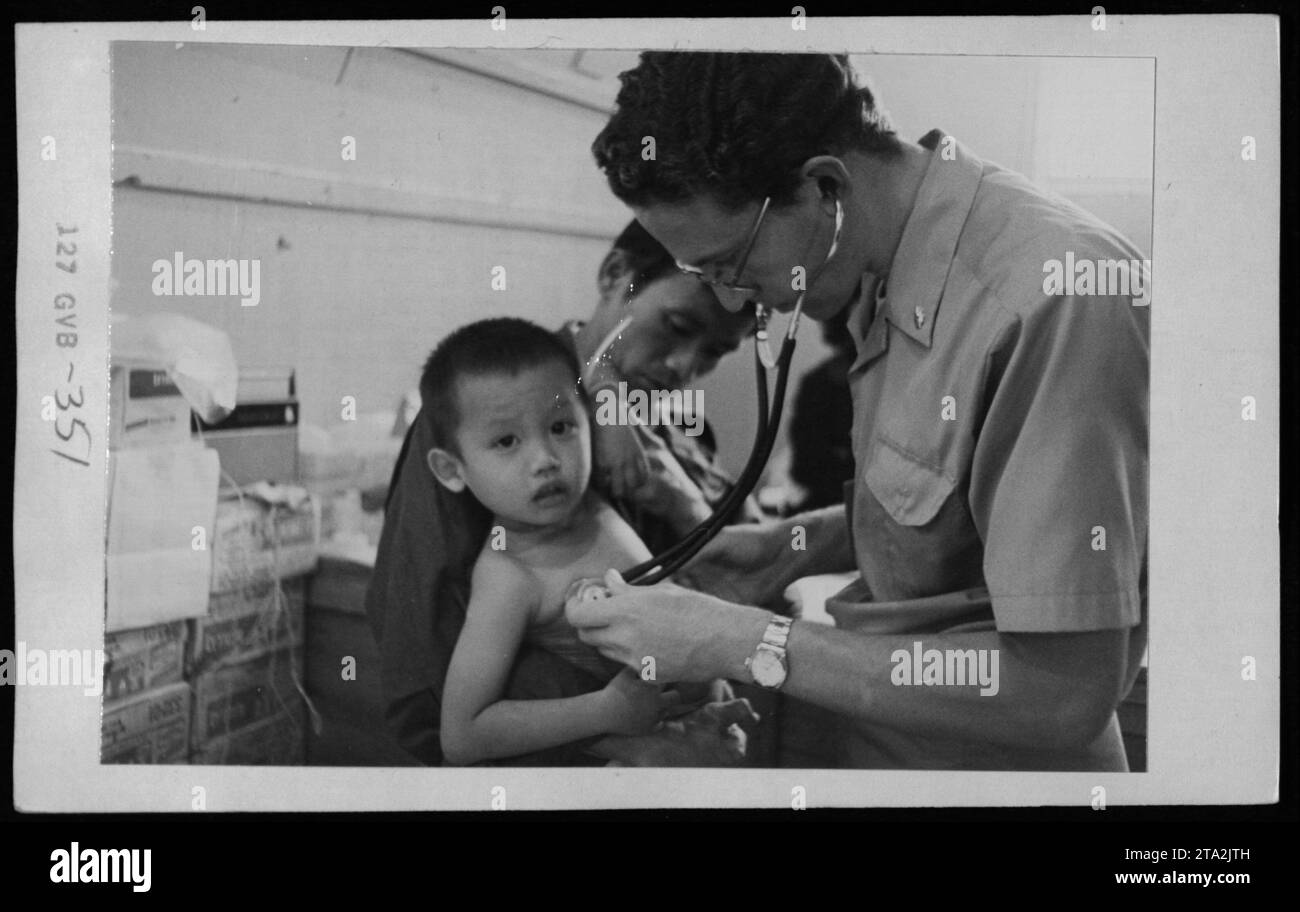 'Vietnamese refugees in the US receiving a visit from Claudia Cardinale, Nguyen Cao Ky, Rosemary Clooney, and Betty Ford on May 5, 1975. The photograph captures the humanitarian efforts to support and provide aid to those affected by the Vietnam War.' Stock Photo