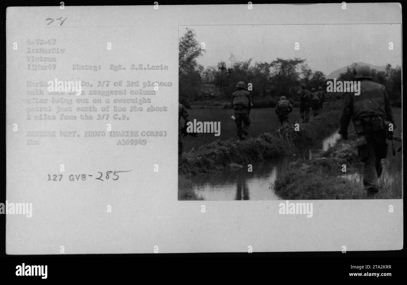 Marines from H Co. 3/7 of 3rd platoon return from an overnight patrol near Due ho during the Vietnam War, on March 13, 1967. The soldiers are seen walking in a staggered column, about 2 miles from their base at 3/7 C.R. EFENSE DERT. EROTO. Photograph taken by Sgt. S.E.Lenin. Stock Photo