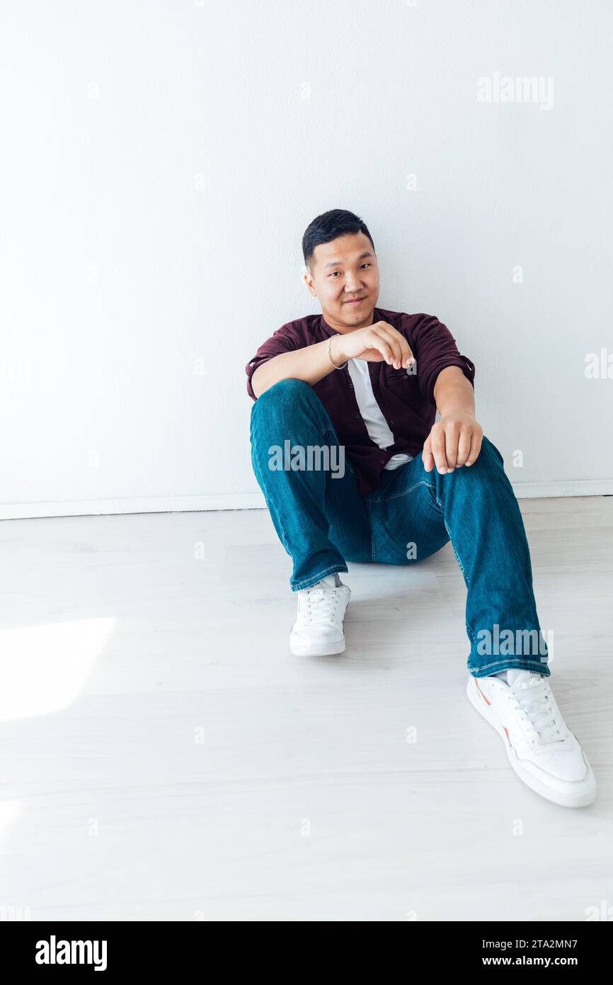 A man sits on the floor on a white background in a studio Stock Photo ...