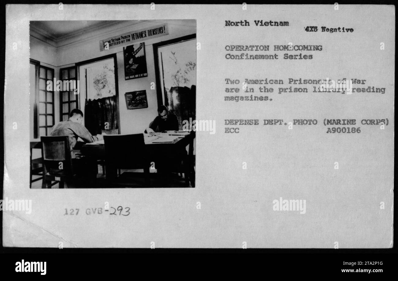 Two American prisoners of war read magazines in a prison library in ...