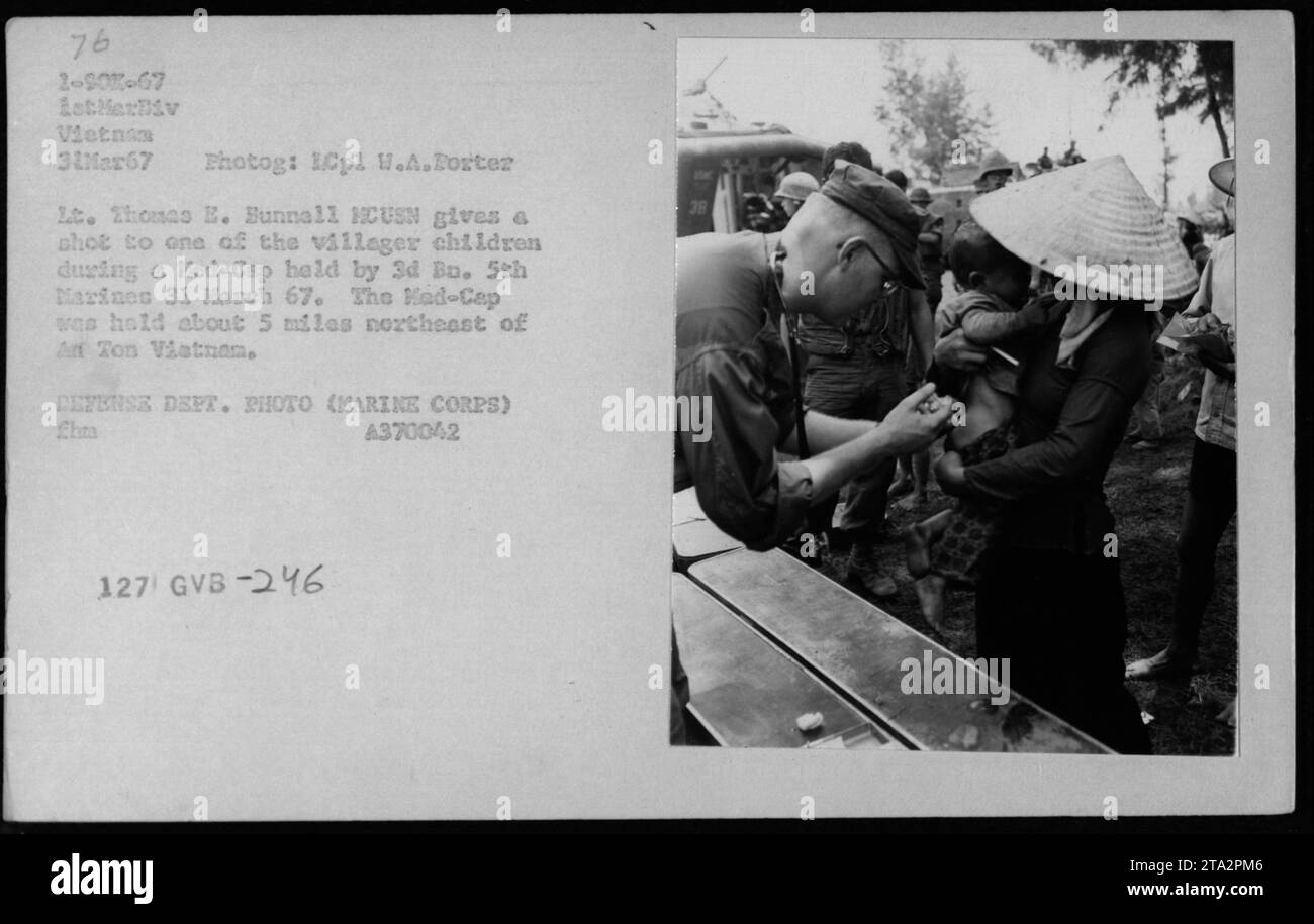 Lt. Thomas E. Sunnall, HCUSN, administers a shot to a child during a Medical Civil Action Program (MEDCAP) held by the 3rd Battalion, 5th Marines on March 31, 1967. The MEDCAP took place approximately 5 miles northeast of An Ton, Vietnam. The photograph is classified as Defense Department photo (Marine Corps), GVB-246. Stock Photo