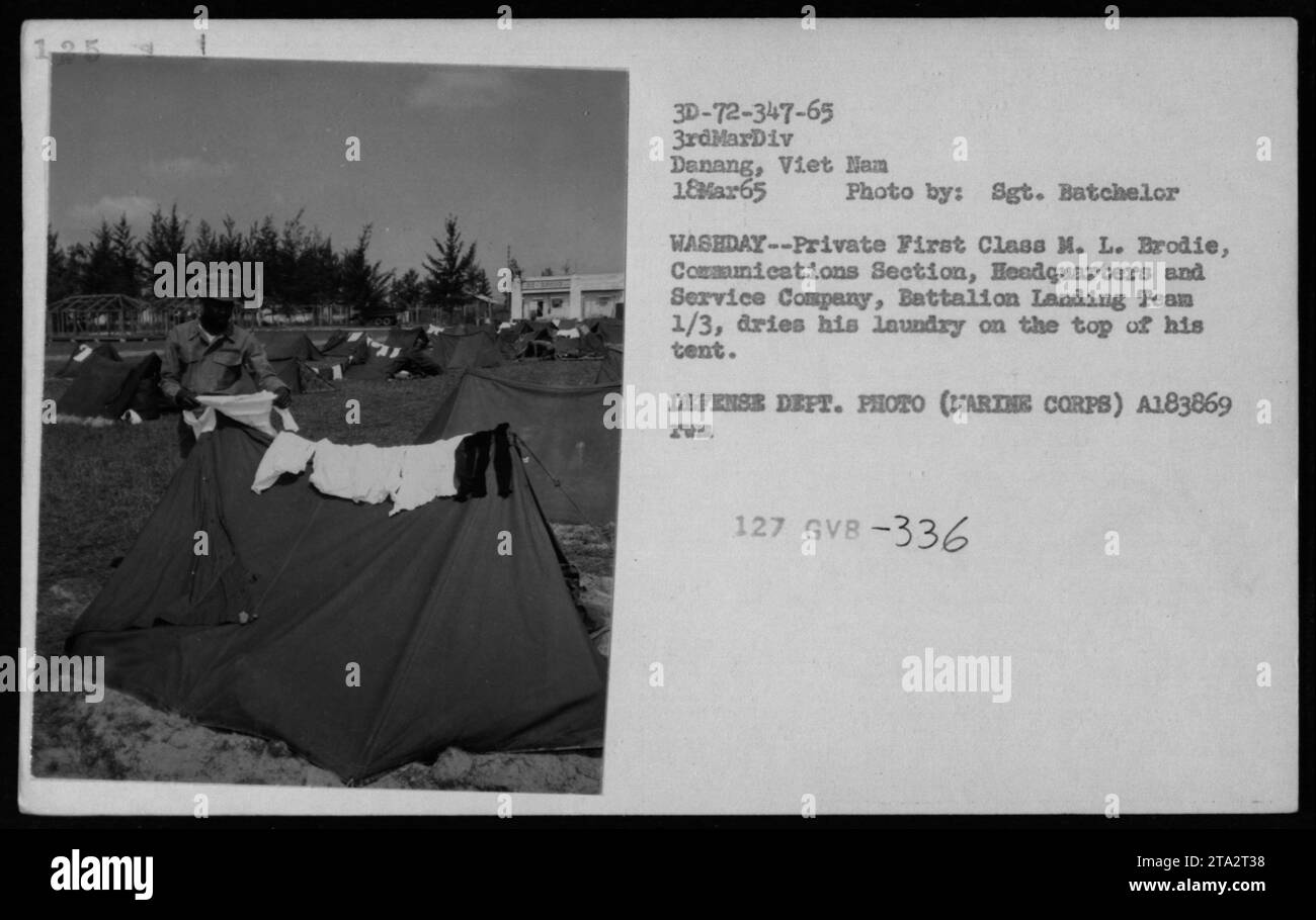 A soldier from Battalion Landing Team 1/3, stationed in Denang, Vietnam, dries his laundry on top of his tent. The photograph, taken on March 18, 1965, captures the daily life of American military personnel during the Vietnam War. Image credit: Sgt. Batchelor. Stock Photo