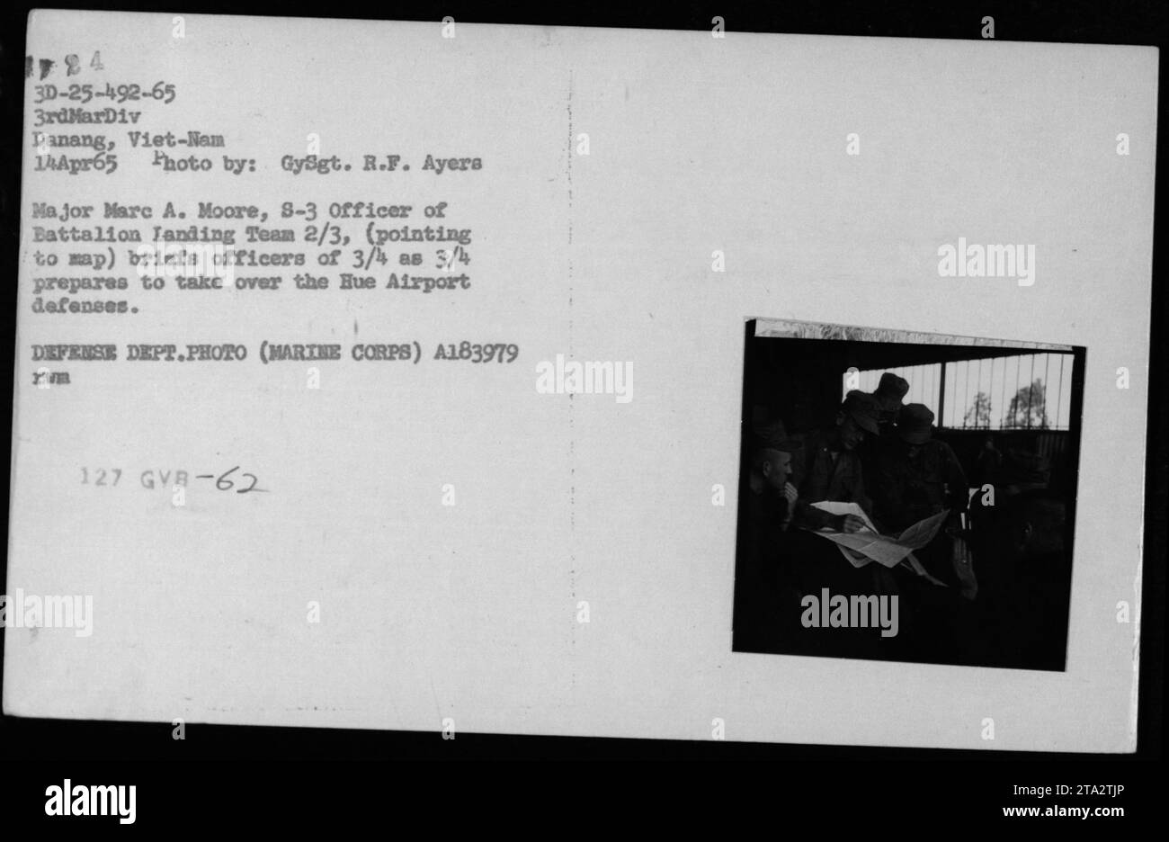 Marine Corps Officer Major Marc A. Moore is seen here conducting a briefing for officers of Battalion Landing Team 2/3. The briefing took place on April 14, 1965, in Danang, Vietnam. Major Moore points to a map while briefing officers of 3/4 as they prepare to take over the defenses of Hue Airport. This photograph was taken by Gysgt. R.F. Ayers. Stock Photo