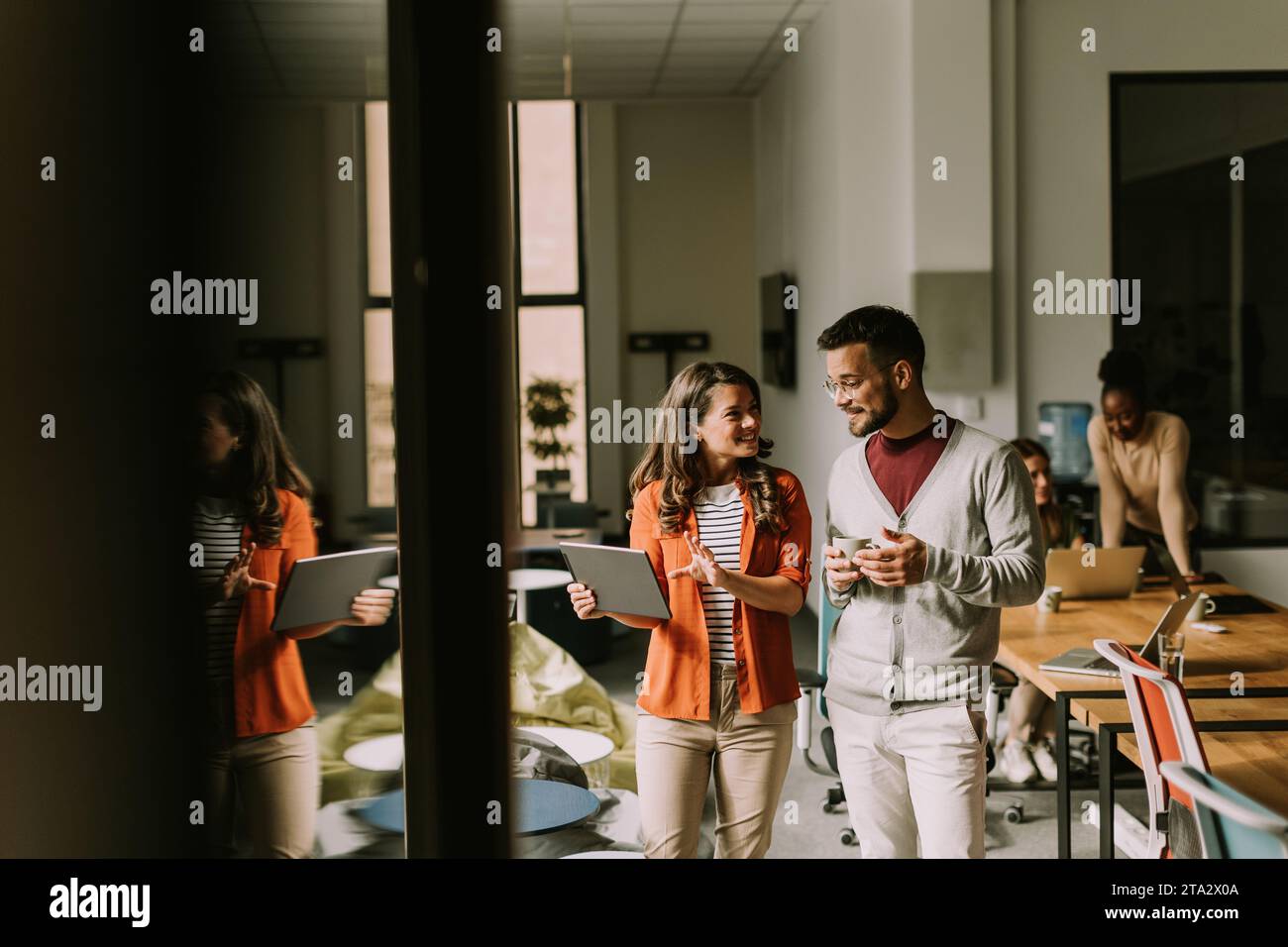 Young business couple standing with digital tablet in front of her team at the modern office Stock Photo