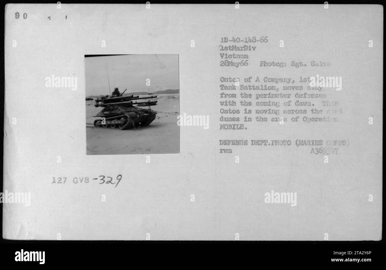 The ONTOS tank, specifically A Company's unit, is captured in action on May 28, 1966 during the Vietnam War. Sgt. Salve Ontos, part of the 1stMarDiv in Vietnam, is photographed as he moves away from the perimeter defenses at sunrise. The tank is seen traversing the sandy dunes in the operation area known as MOBILE. This photo is an official Defense Department image taken by Sgt. Salve. Stock Photo