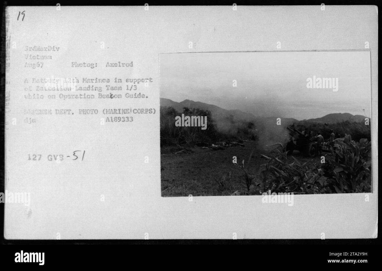 'Marines from A Battery 12th Marines provide artillery support to Battalion Landing Team 1/3 during Operation Beacon Guide in August 1967 in Vietnam. This Defense Department photograph, taken by Axelrod, depicts the seamless coordination between ground troops and artillery units during the Vietnam War.' Stock Photo