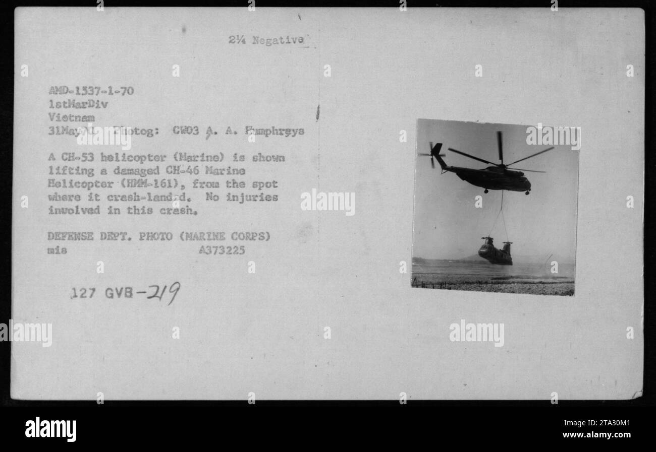 A CH53 Marine helicopter is seen in the process of lifting a damaged CH46 Marine helicopter