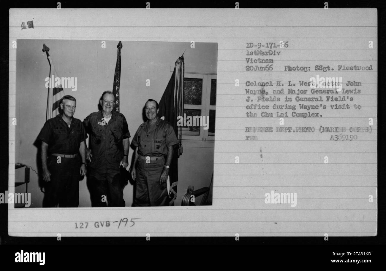 Colonel H. L. West, actor John Wayne, and Major General Levis J. Helds at General Field's office, Chu Lai Complex in Vietnam on June 20, 1966. John Wayne visited the military base during the war. Photograph taken by SSgt. Fleetwood, part of the U.S. Defense Department's collection (MARX COR:3). Stock Photo