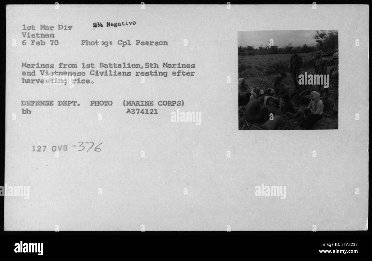 Marines from 1st Battalion, 5th Marines and Vietnamese civilians take a break after harvesting rice in Vietnam on February 6, 1970. The photograph shows a moment of respite amidst the ongoing conflict, capturing a different aspect of Vietnamese civilian life during the Vietnam War. DEFENSE DEPT. PHOTO (MARINE CORPS) bh A374121 127 GVB -376. Stock Photo