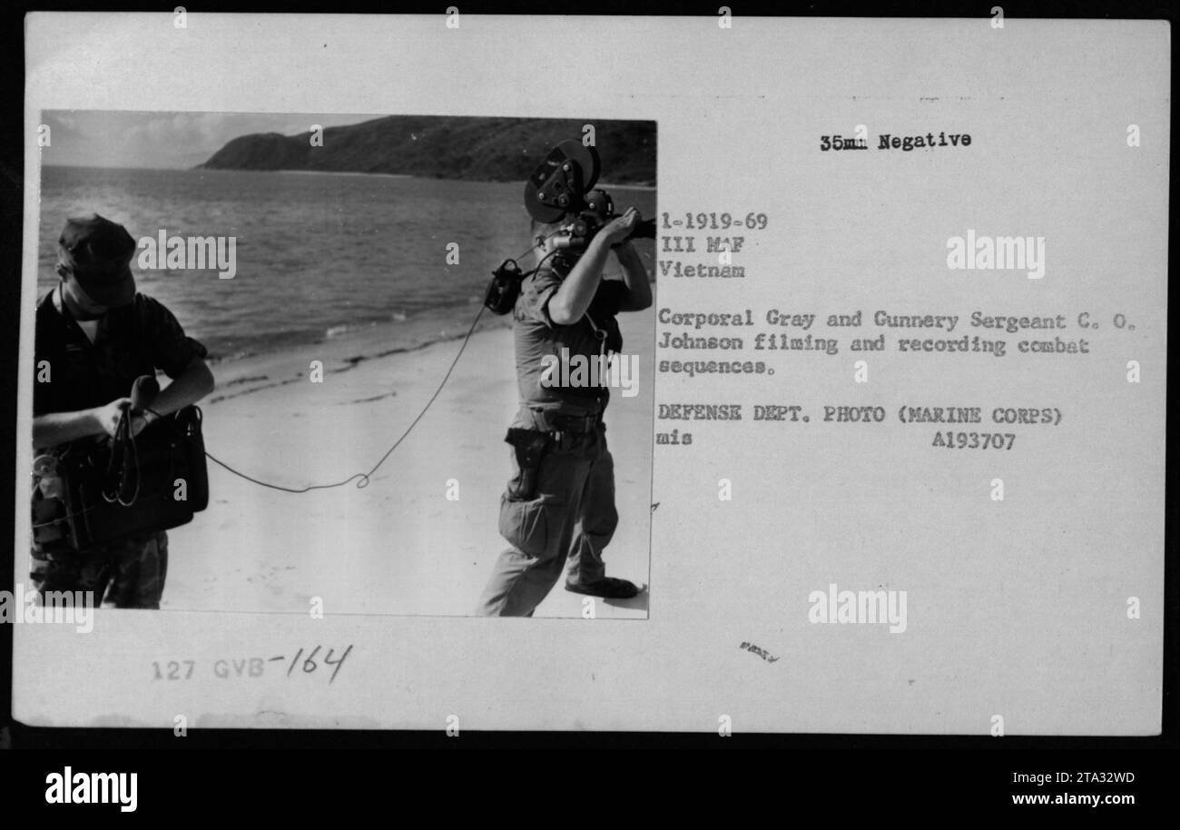 Combat photographers Corporal Gray and Gunnery Sergeant C.O. Johnson film and record combat sequences during the Vietnam War. Image taken by Larry Burrows of Time/Life, part of the III Marine Amphibious Force in Vietnam. This is an official Department of Defense photograph. Stock Photo