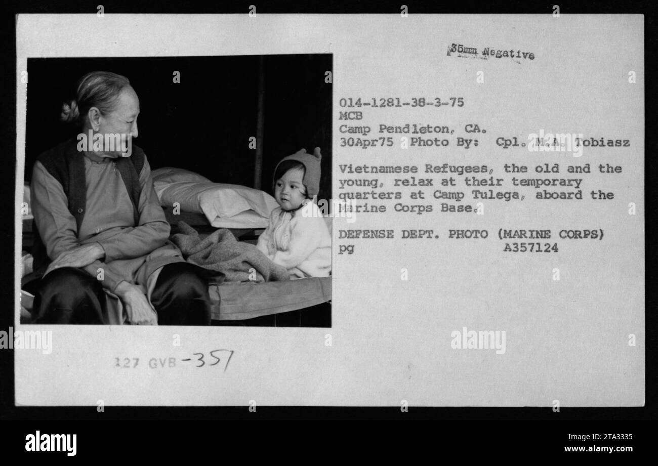 Vietnamese refugees, including the young and the elderly, find temporary shelter at Camp Tulega, located within Marine Corps Base Camp Pendleton in California. The image captures a visit by Claudia Cardinale, Nguyen Cao Ky, Rosemary Clooney, and Betty Ford to these refugees on April 30, 1975. This photograph was taken by Cpl. M.A. Tobiasz and is part of the collection of American military activities during the Vietnam War. Stock Photo