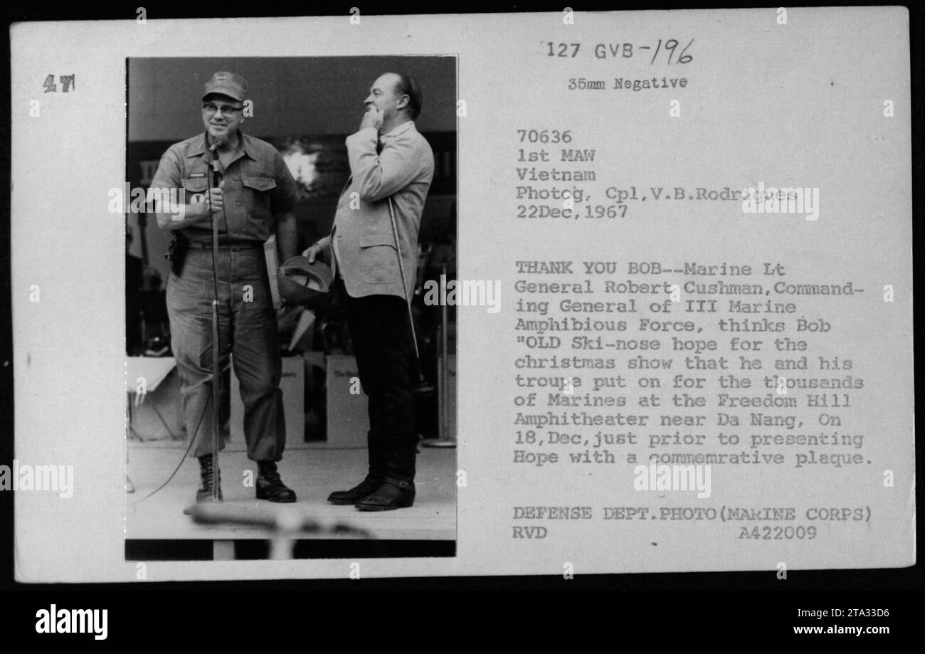 Marine Lt General Robert Cushman presents Bob Hope with a commemorative plaque after the Christmas show Bob and his troupe performed for the Marines at Freedom Hill Amphitheater near Da Nang on December 18, 1967. The photograph captures the gratitude and appreciation expressed towards Bob Hope for entertaining thousands of Marines during the Vietnam War. Stock Photo