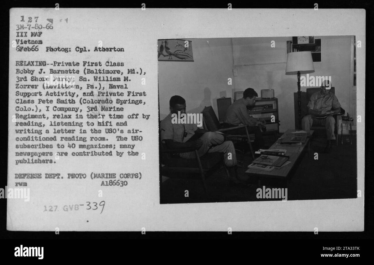 USO's air-conditioned reading room provided a relaxing setting for servicemen during the Vietnam War. In this photo, Private First Class Bobby J. Barnette, Sn. William M. Zorrer, and Private First Class Pete Smith are seen enjoying their time off by reading, listening to music, and writing letters. The room offered access to 40 magazines and numerous newspapers. Stock Photo