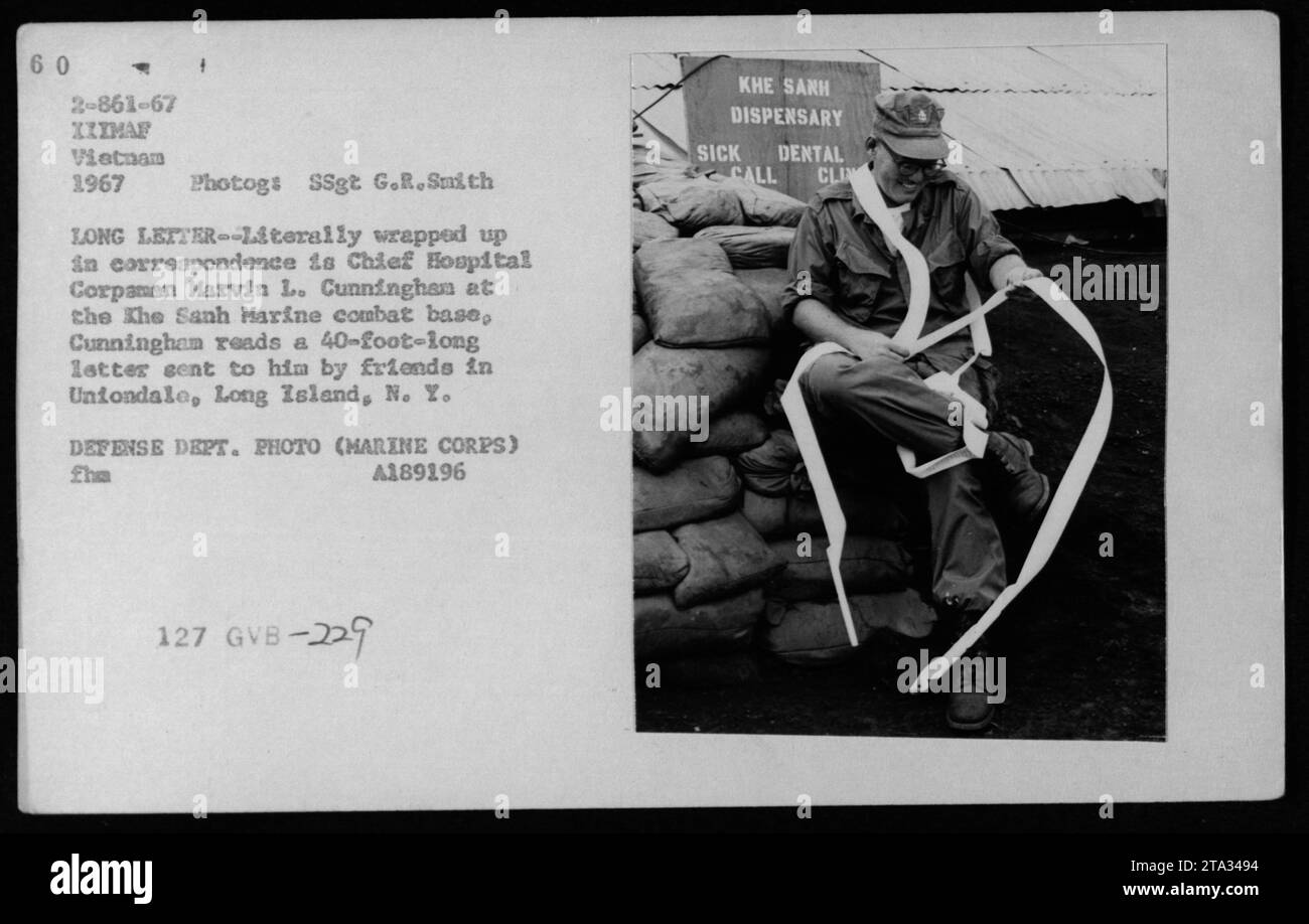 Marine Corps Chief Hospitalman Marvin L. Cunningham at the Khe Sanh Marine combat base reading a 40-foot-long letter sent from friends in Uniondale, Long Island, NY. The photo was taken in 1967 during the Vietnam War. Cunningham is seen in the Khe Sanh Dispensary. Photograph by SSgt G.R. Smith. Stock Photo