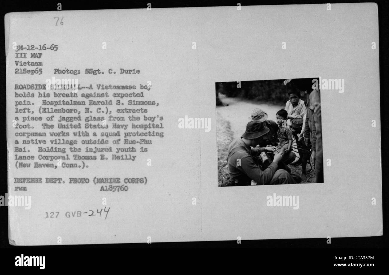 US Navy hospital corpsman, Harold S. Simmons, extracts a piece of glass from a Vietnamese boy's foot during a roadside sick call in Vietnam. The boy braces himself for pain while Lance Corporal Thomas B. Reilly holds him. This activity took place outside of Hue-Phu Bai as part of a medical mission for the local village. Defense Department photo, A185760. Stock Photo