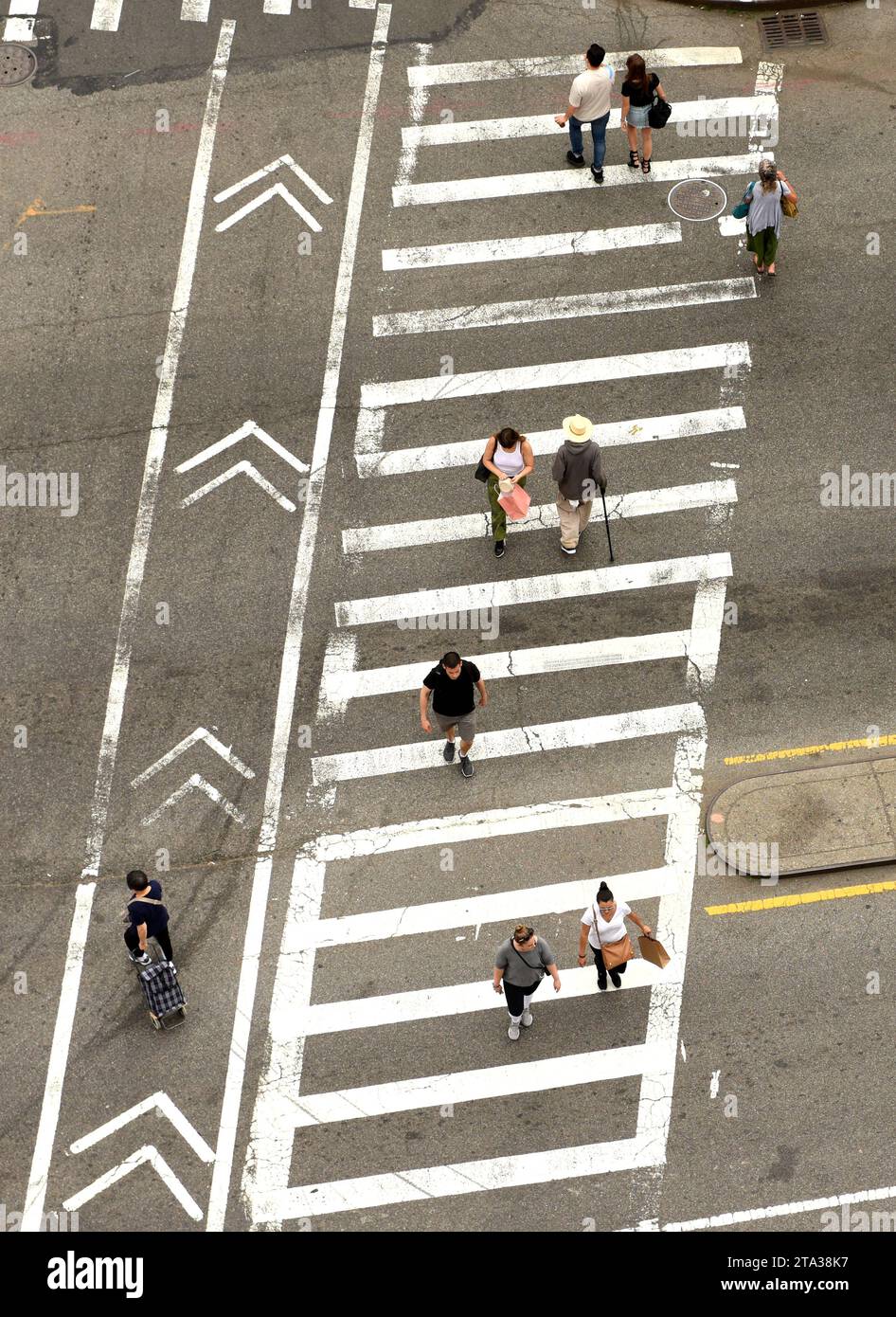 New York, USA - June 9, 2018: People walking on zebra crossings in New York. Looking down from skyscraper on the busy streets in New York. Stock Photo