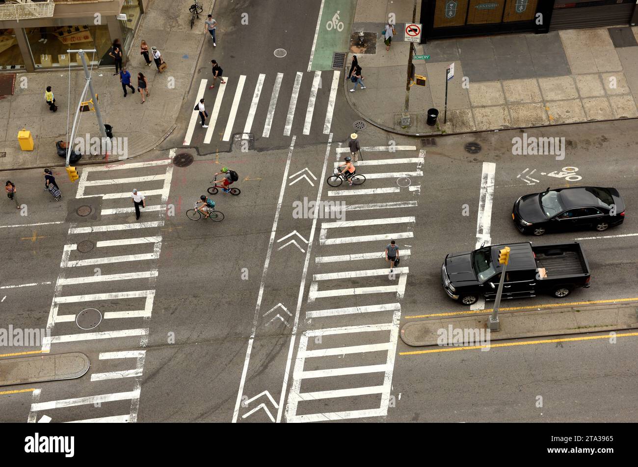 New York, USA - June 9, 2018: People walking on zebra crossings in New York. Looking down from skyscraper on the busy streets in New York. Stock Photo