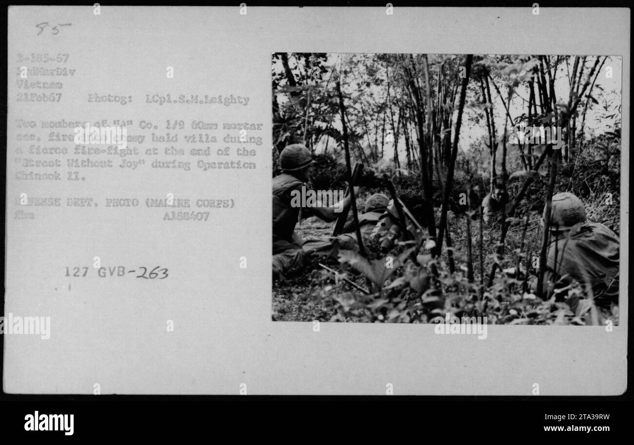 In this photograph taken on February 21, 1967, members of 'A' Co. 1/9 are seen firing 60mm mortars into an enemy-held villa during a fierce firefight at the end of 'Street Without Joy' as part of Operation Chinook II. This image is from the collection of Photographs of American Military Activities during the Vietnam War, captured by LCpl.S.M.Leighty. Stock Photo