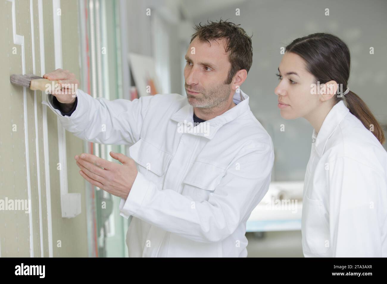 female apprentice decorator in training Stock Photo