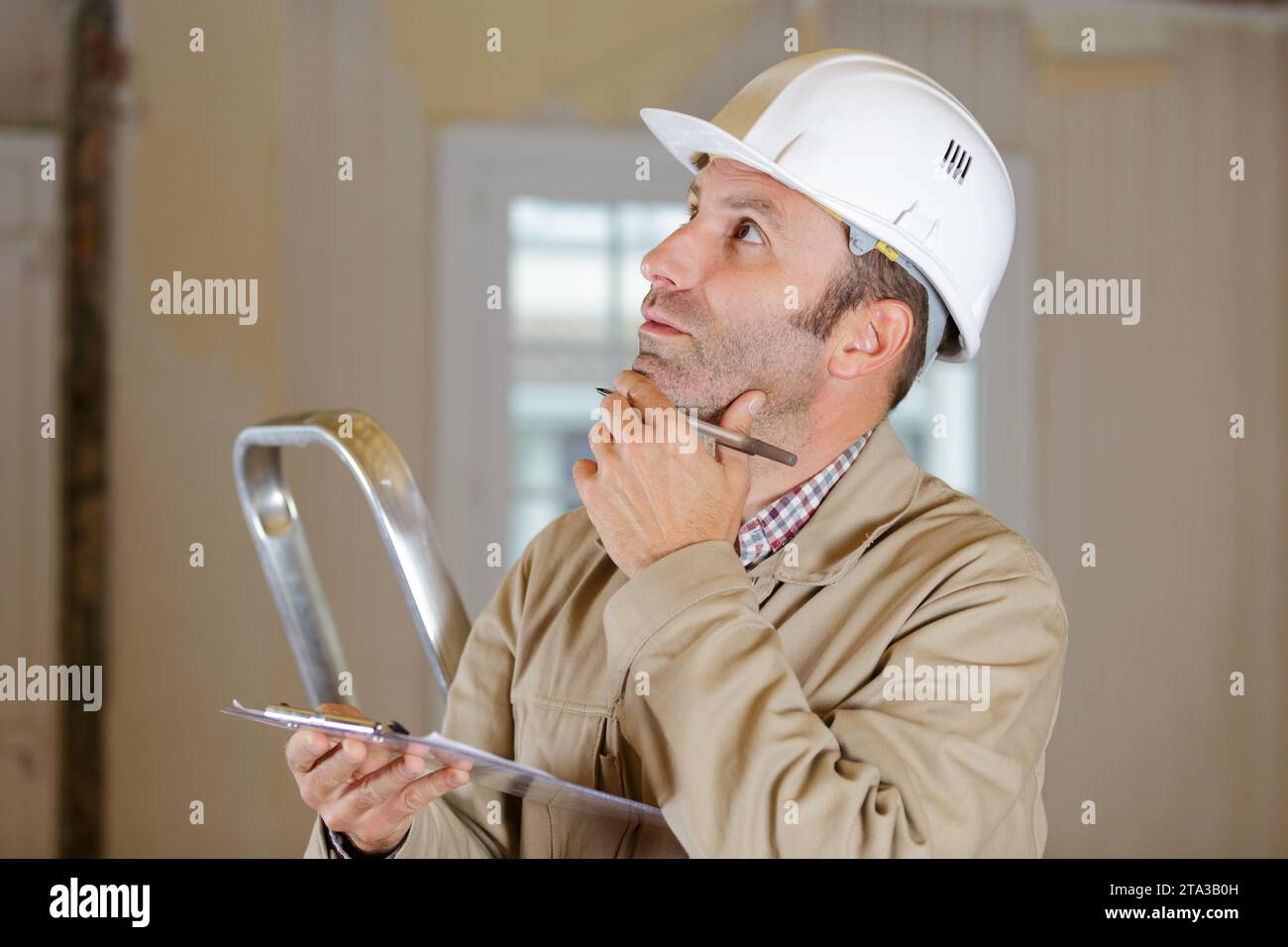 mature builder writing something on site plans Stock Photo