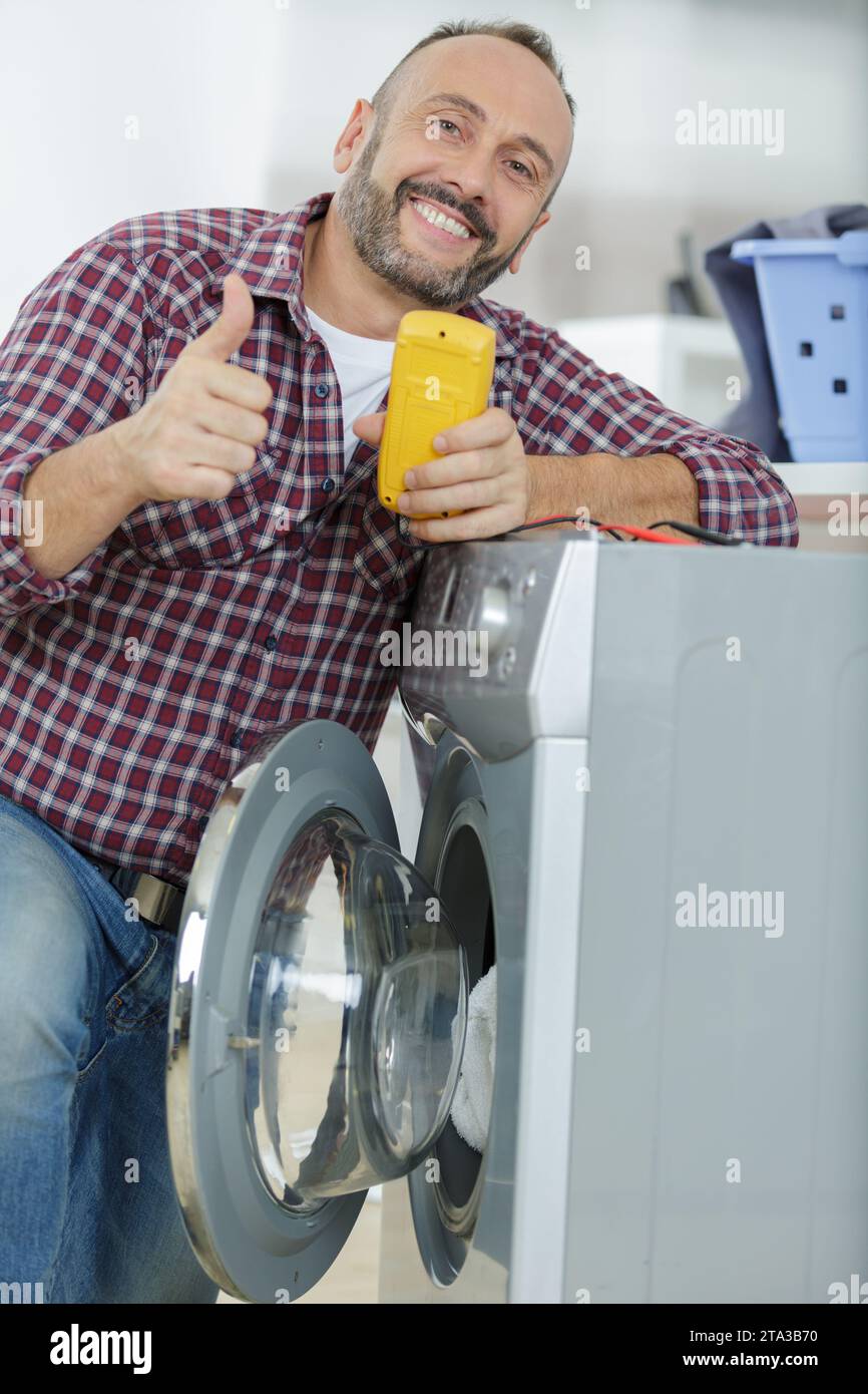 echnician checking machine with digital multimeter Stock Photo