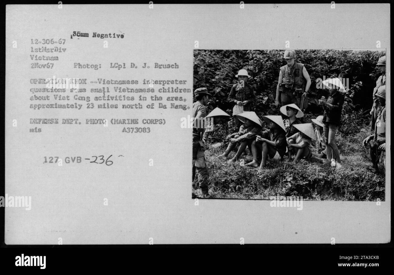 A Vietnamese interpreter interrogates small Vietnamese children about Viet Cong activities in the area, approximately 23 miles north of Da Nang during Operation KHOX. This image was taken on November 2, 1967, by LCpl D. J. Brusch of the 1stlarDiv in Vietnam. The photograph is a 35mm negative, catalog number 12-306-67, and is an official Defense Department photo (Marine Corps). Reference code: reis A373083 127 GVB-236. Stock Photo