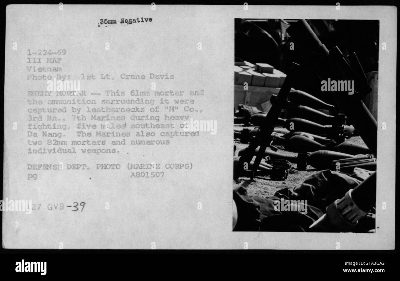 'Captured enemy weapons and ammunition displayed by U.S. Marines. In this photograph, leathernecks of 'M' Company, 3rd Battalion, 7th Marines showcase a captured 61mm mortar and the surrounding ammunition. This acquisition was made during intense fighting, approximately five miles southeast of Da Nang. Alongside the mortar, the Marines also seized two 82mm mortars and various individual weapons. Image source: Defense Department, Marine Corps.' Stock Photo