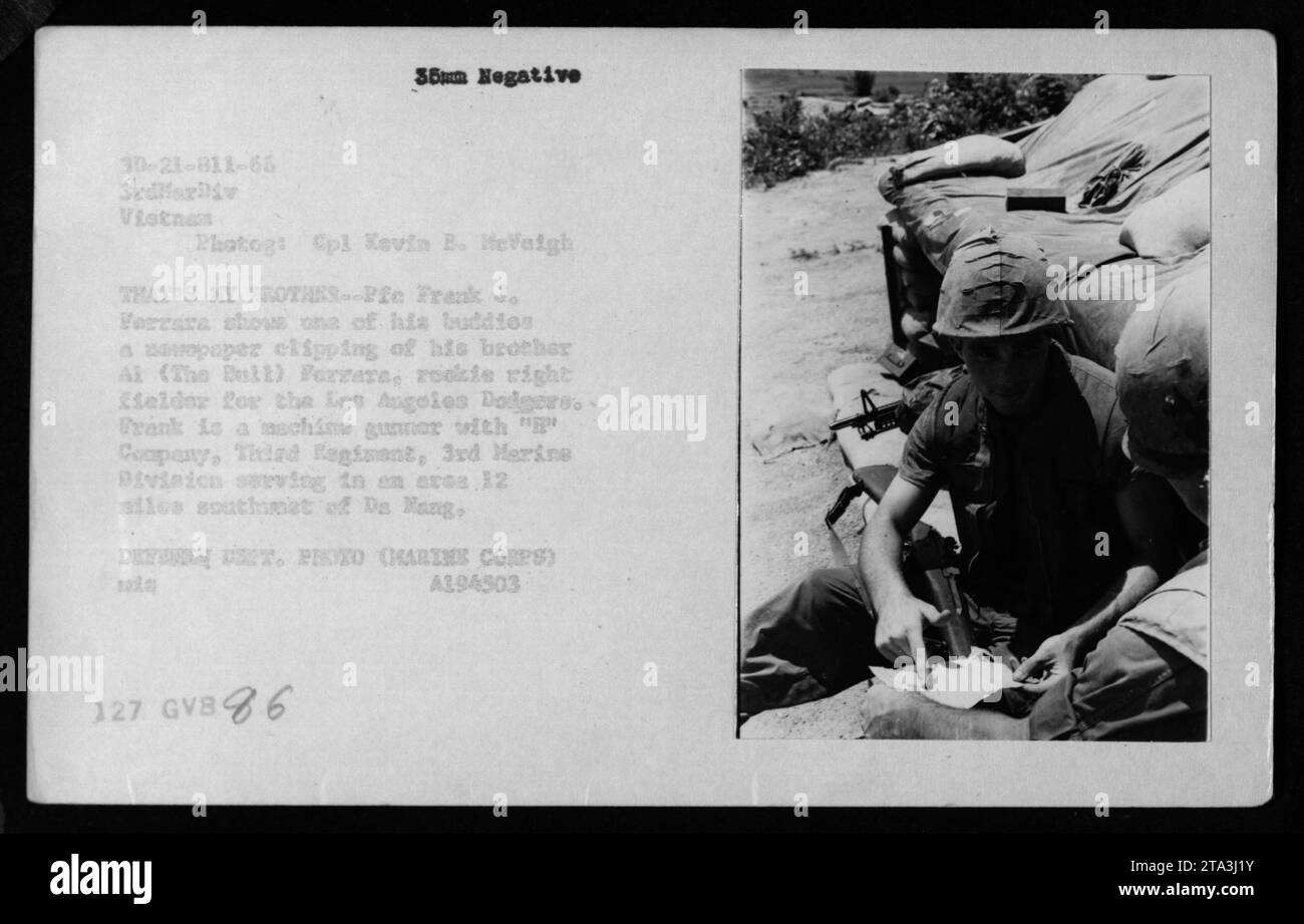 'Marine Corps Corporal Kevin B. MeVaigh captures a poignant moment during combat in Vietnam in 1966. Private First Class Frank J. Ferrara, a machine gunner with 'C' Company, Third Regiment, 3rd Marine Division, shows a newspaper clipping featuring his brother, rookie baseball player Ai 'The Bull' Ferrara of the Los Angeles Dodgers. The image was taken in an area 12 miles southwest of Da Nang.' Stock Photo
