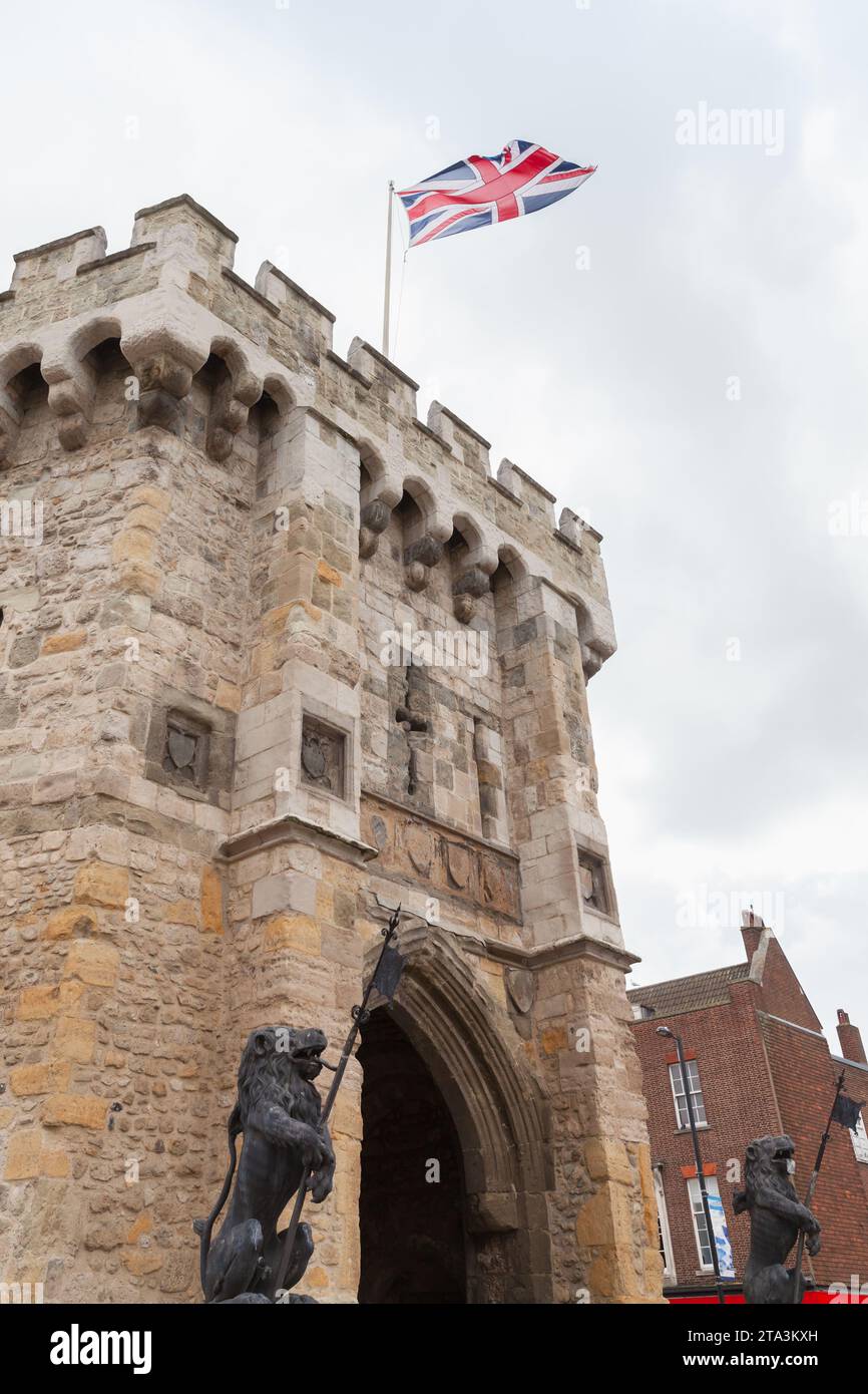 Vertical photo with the British flag is on the Bargate. It is a medieval gatehouse in the city of Southampton, England. Constructed in Norman times as Stock Photo