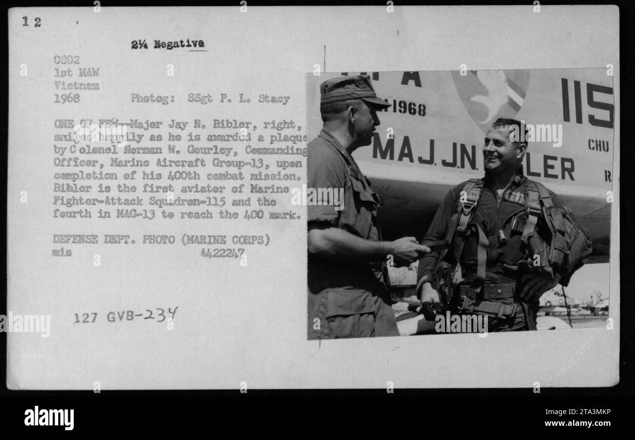 Major Jay N. Bibler of Marine Fighter-Attack Squadron-115 smiles as he receives a plaque from Colonel Norman W. Gourley, Commanding Officer of Marine Aircraft Group-13, for completing his 400th combat mission. Bibler is the first aviator in his squadron and the fourth in MAG-13 to reach this milestone. Stock Photo