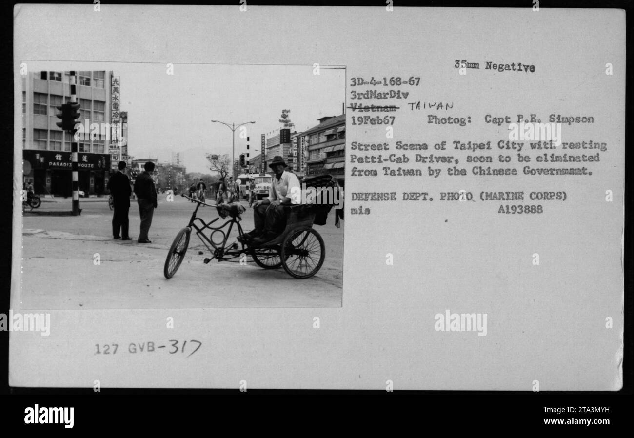 Image: A black and white photograph taken on February 19, 1967, during the Vietnam War. The photo depicts a street scene in Taipei City, Taiwan. In the foreground, a resting petti-cab driver can be seen. The photograph was taken by Captain B.E. Simpson of the U.S. Marines. Stock Photo