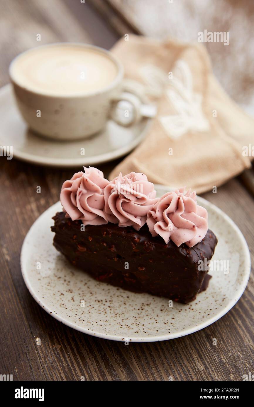 Traditional brownie cake with cup of cappuccino outdoor. Winter aesthetics. Stock Photo