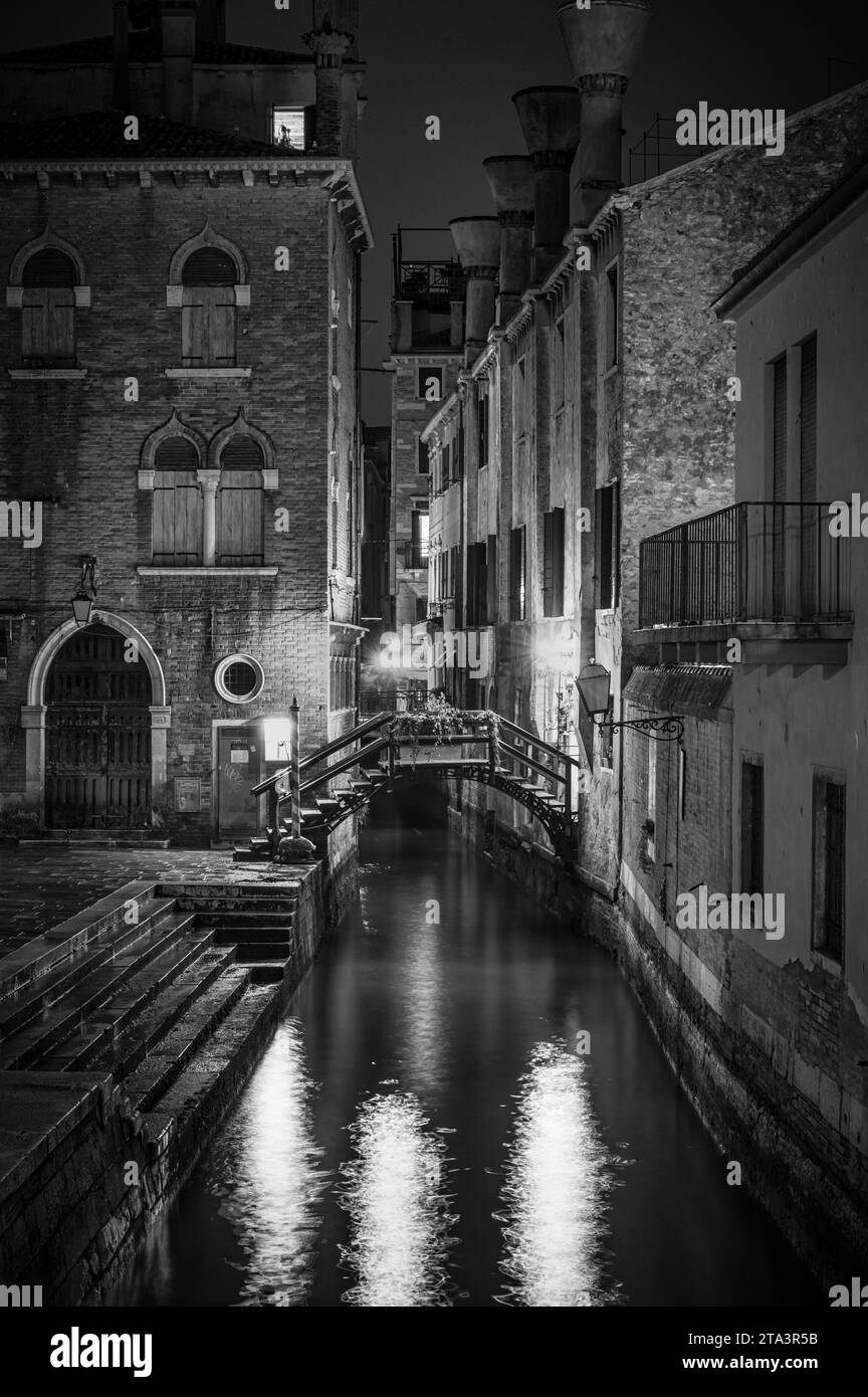 Venice, Italy- Feb 22, 2023: The side canal at the  Rialto Market in Venice at night Stock Photo