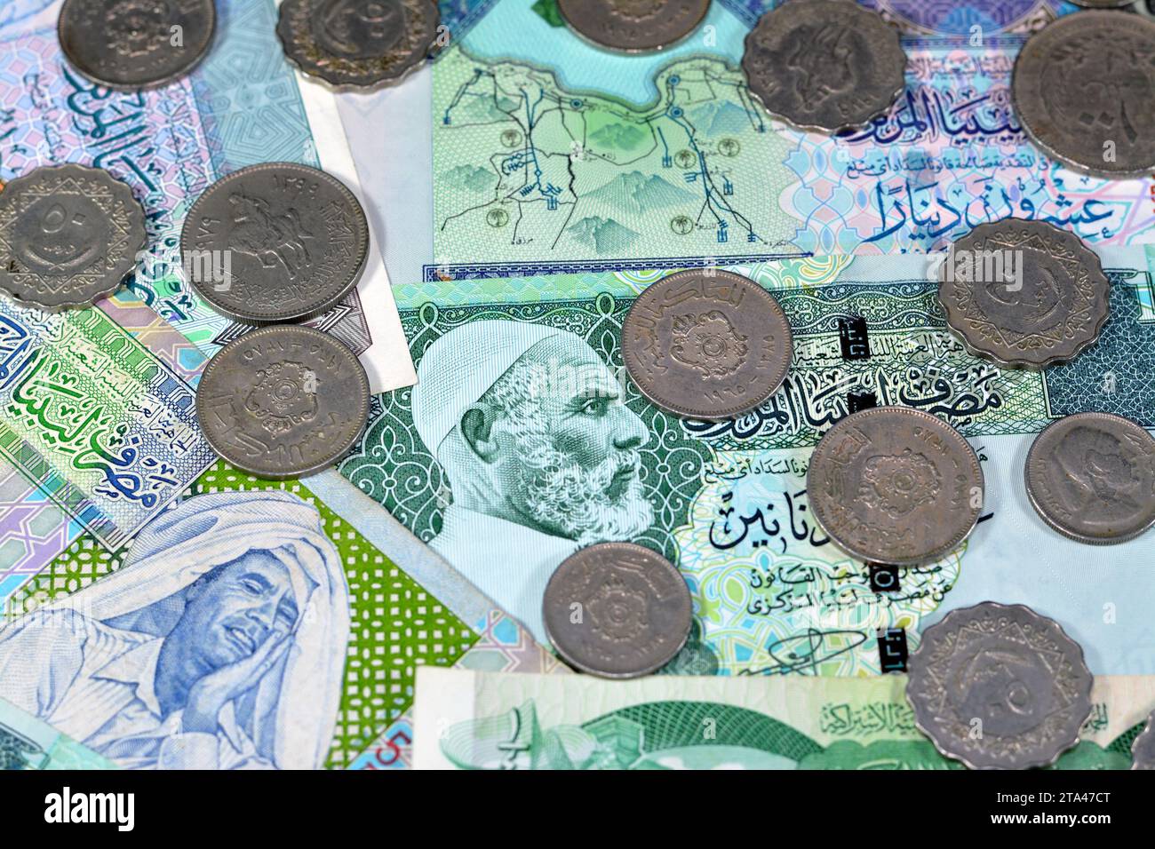 Background of old Libyan money banknote bills and coins of different eras from the kingdom to Jamahiriya of Libya times, vintage retro old Libyan curr Stock Photo