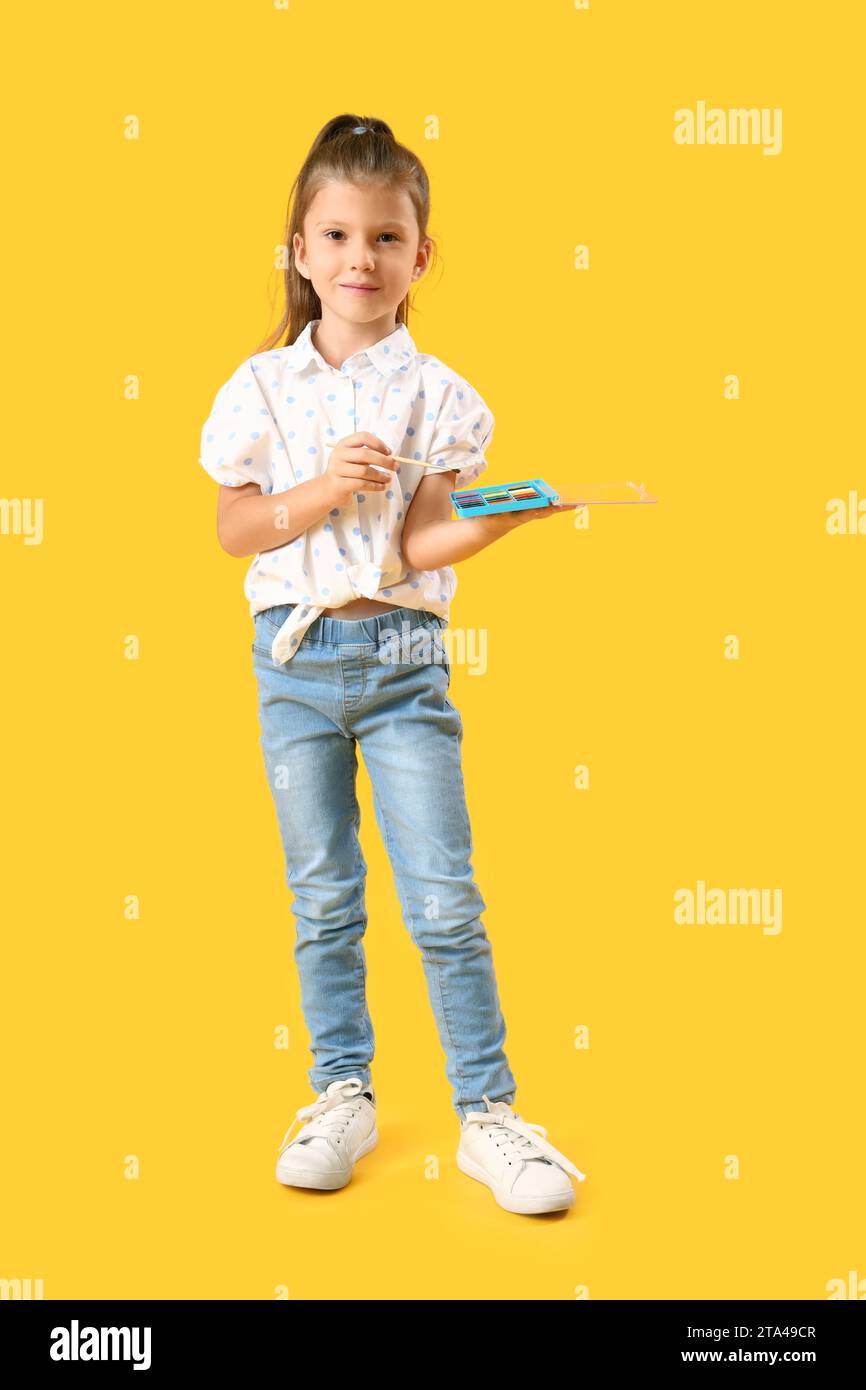 Cute little girl with brush and paints on yellow background Stock Photo ...