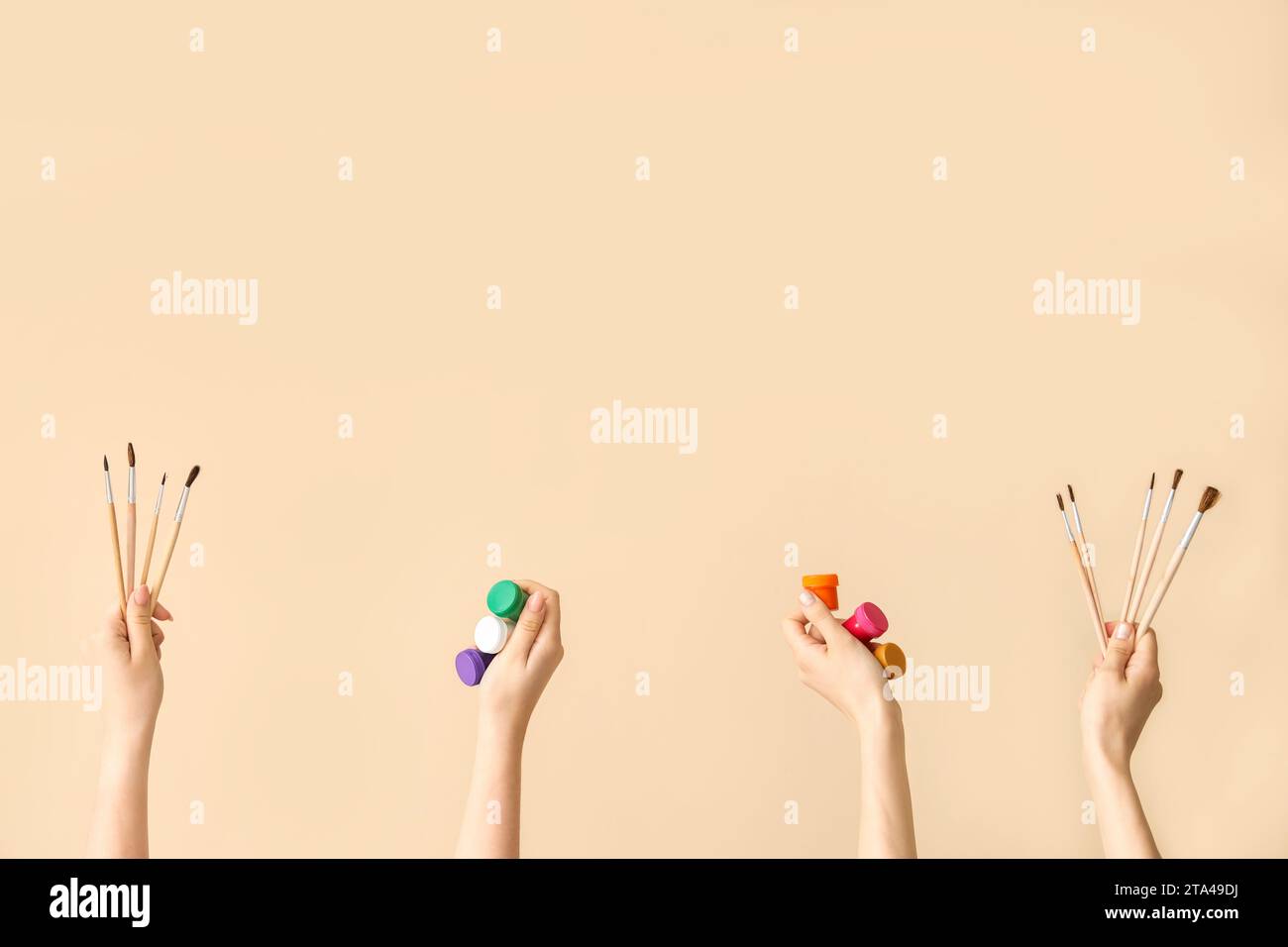 Female hands with artist's supplies on beige background Stock Photo - Alamy