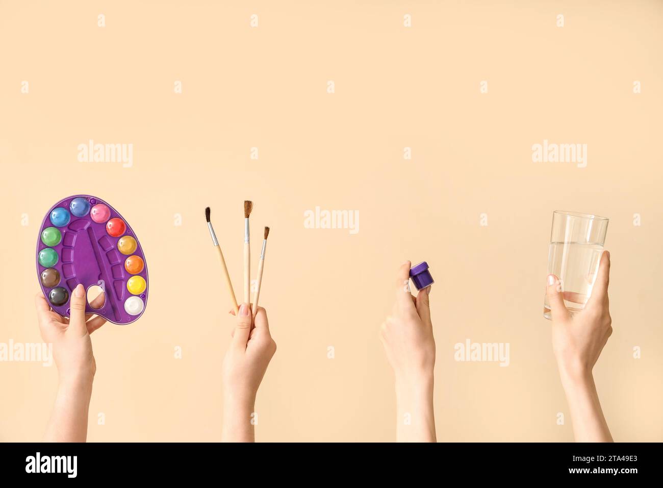 Female hands with artist's supplies on beige background Stock Photo - Alamy