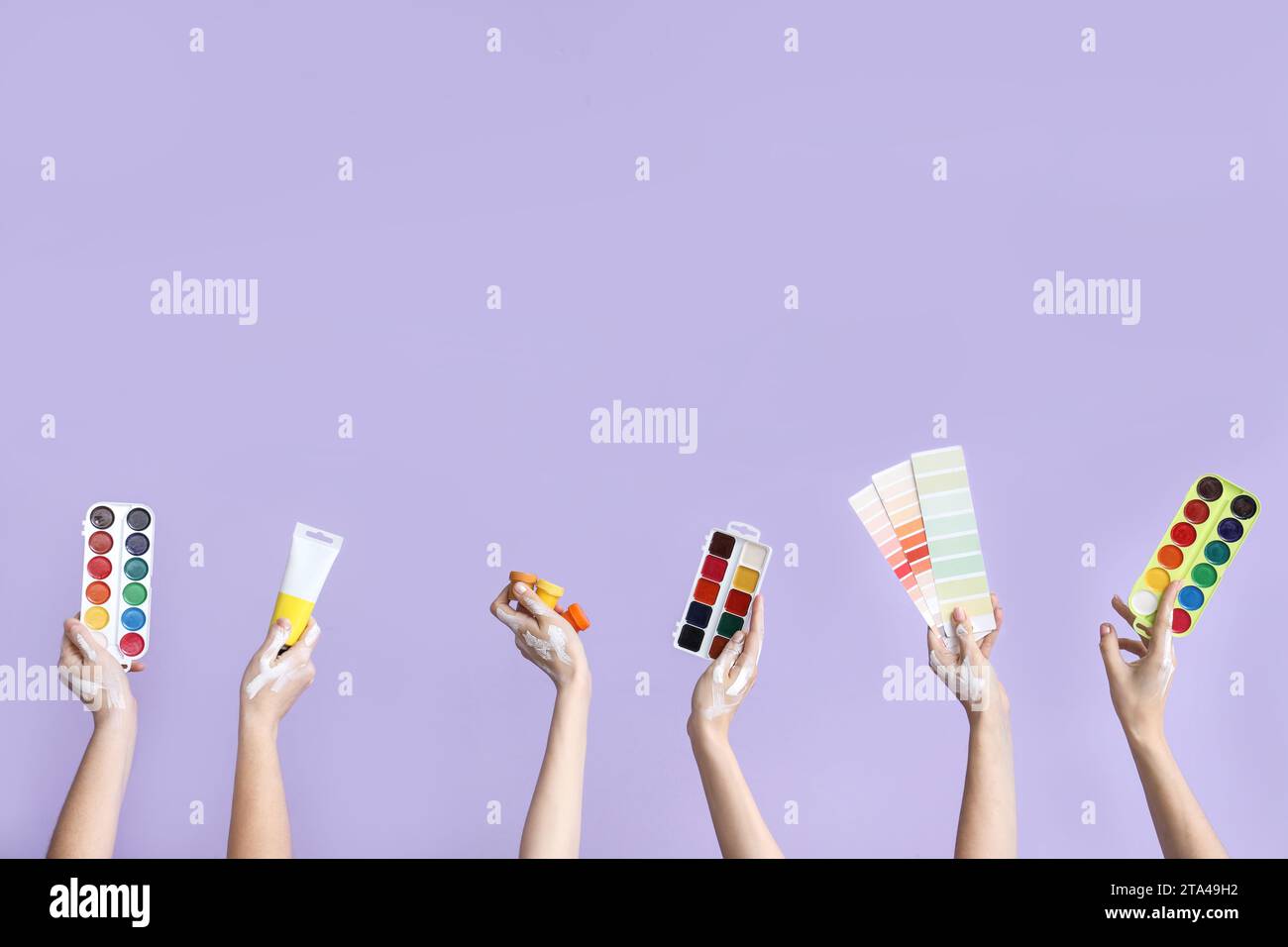 Female hands with artist's supplies on lilac background Stock Photo - Alamy
